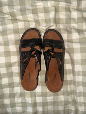 Clarks Black Leather Slip-On Sandals with Brown Footbed